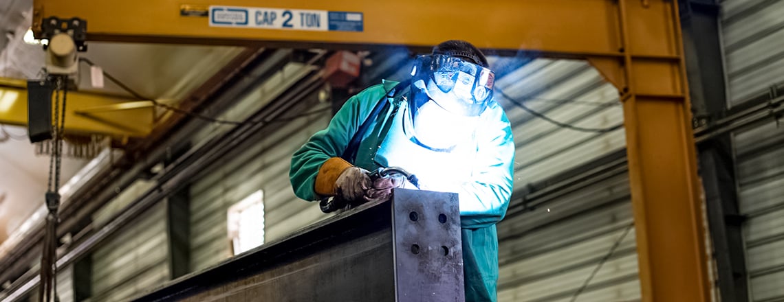 Welder welding steel frames in Legacy steel plant